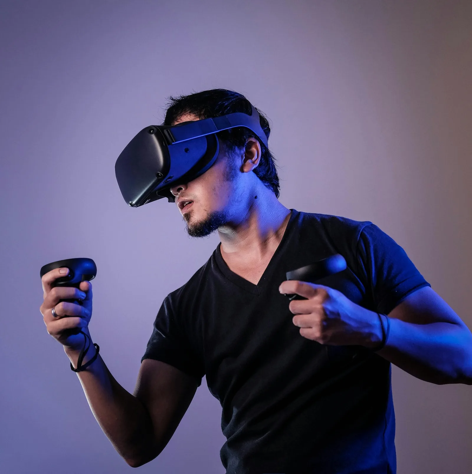 Person wearing a virtual reality headset and holding two controllers