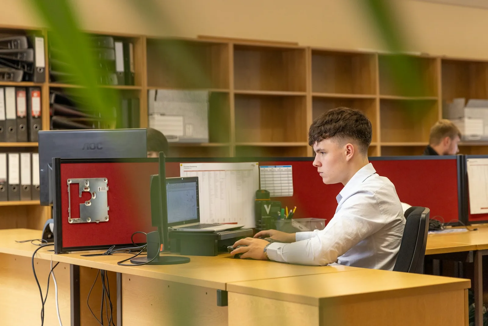 Person working at a computer in a shared workspace